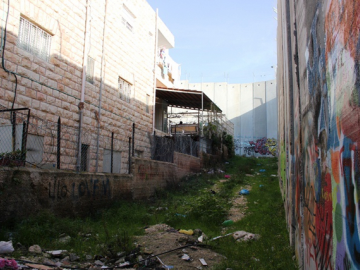 This house in Bethlehem is flagged by the Wall on three sides.